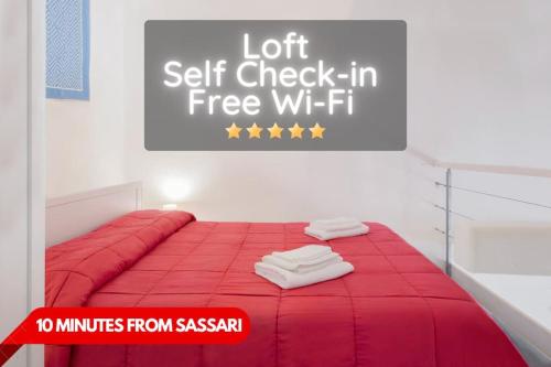 Una cama roja en una habitación con un cartel. en Sorres Home & Relax 10 min da Sassari Loft AC e WiFi, en Codrongianos