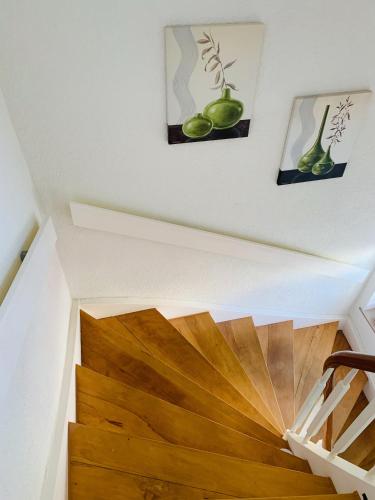 a staircase with wood floors and paintings on the walls at SEEMOMENTE Spieleland, Messe, Friedrichshafen 3 Zi mit Balkon, Parkplatz in Meckenbeuren