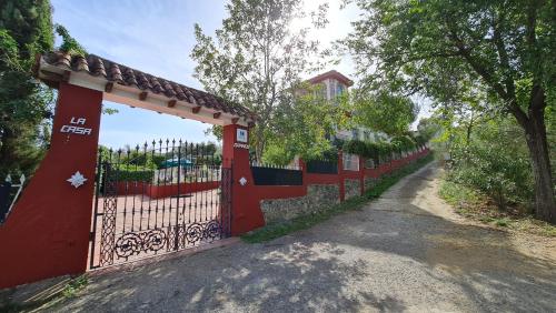 una valla roja con una puerta en una carretera en LA CASA GRANDE, en Sevilla
