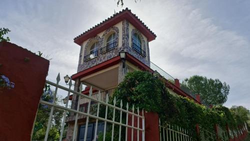 un gran edificio rojo con una valla blanca en LA CASA GRANDE, en Sevilla