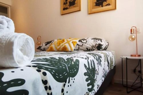 een slaapkamer met een bed met een bloemendeken bij Close to Palais, quiet and comfortable in Cannes