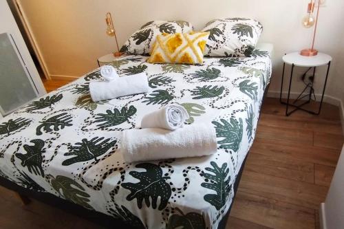 een slaapkamer met een wit en groen bed en handdoeken bij Close to Palais, quiet and comfortable in Cannes