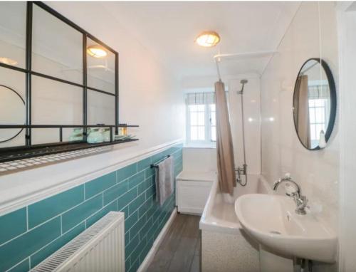a bathroom with a sink and a mirror at Tubs Cottage in Kingsteignton