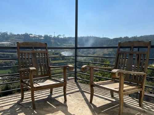 two chairs sitting on top of a balcony with a view at Crush Va Toi in Da Lat