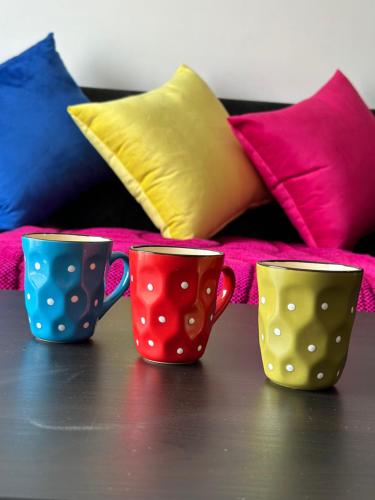 three coffee cups sitting on a table with pillows at Pink House Martil in Martil