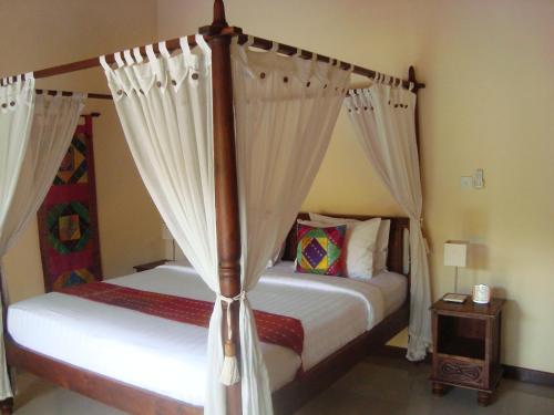 a bedroom with two beds with white curtains at Bali Emerald Villas in Sanur