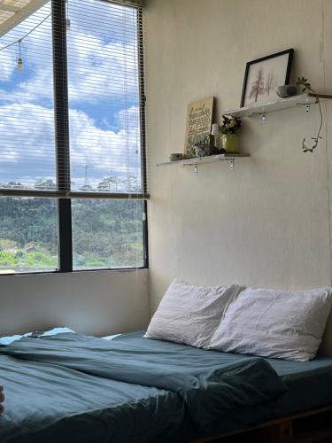 a bed in a bedroom with two windows at Crush Va Toi in Da Lat