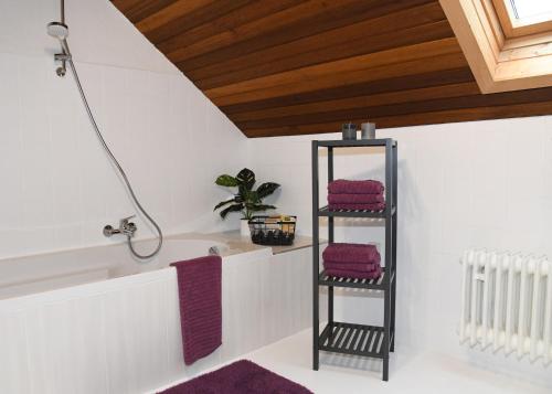 Ferienhaus Dröfter Blick في مونشاو: حمام مع رف للمناشف السوداء مع مناشف أرجوانية