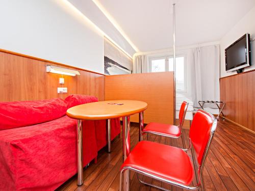 a small room with a table and a red couch at Omena Hotel Turku Humalistonkatu in Turku