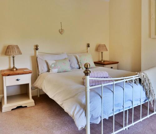 a bedroom with a bed and two night stands at Country Cottage with Far Reaching Views in Presteigne