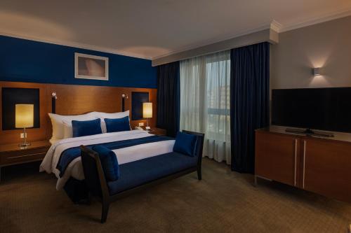 a hotel room with a large bed and a television at Radisson Blu Hotel, Cairo Heliopolis in Cairo