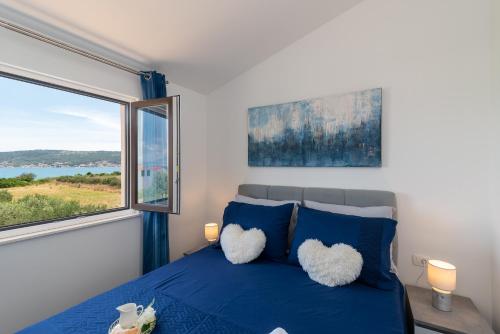 una camera con un letto blu e una grande finestra di Amazing sea view apartment- Romantica a Kaštel Štafilić