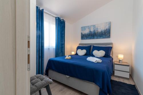 a bedroom with a blue bed and a chair at Amazing sea view apartment- Romantica in Kastel Stafilic