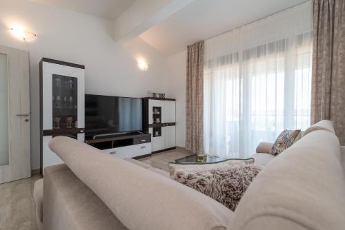 a living room with a couch and a tv at Amazing sea view apartment- Romantica in Kastel Stafilic