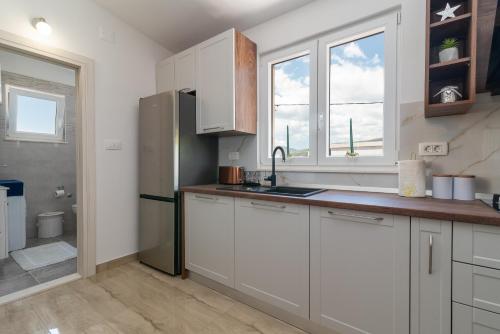 a kitchen with white cabinets and a sink at Amazing sea view apartment- Romantica in Kastel Stafilic