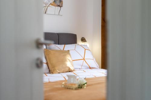 a bed with pillows on it in a room at Amazing sea view apartment- Romantica in Kastel Stafilic