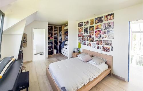 ein Schlafzimmer mit einem großen Bett und Bildern an der Wand in der Unterkunft Gorgeous Home In Pierre-leve With Kitchen 