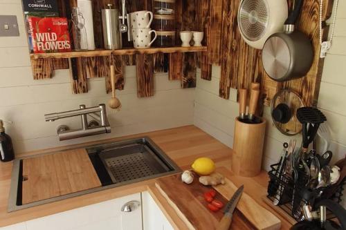 a kitchen with a sink and a cutting board at Gillan Creek Retreat in Helston