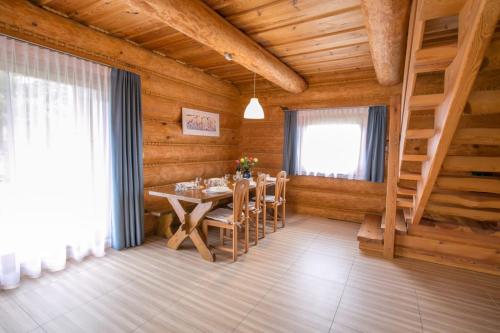 uma sala de jantar com uma mesa numa casa de madeira em u Marysi em Polanica-Zdrój