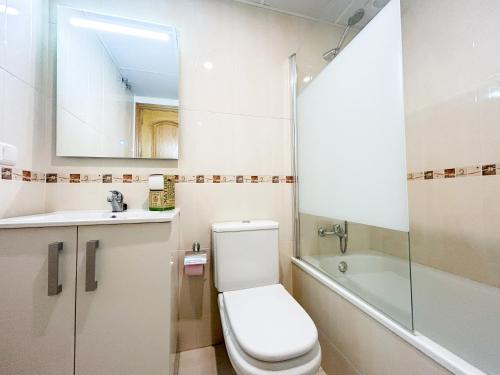 a bathroom with a toilet and a sink and a mirror at Apartment on the 1st line of the Sabinillas beach with sea views in San Luis de Sabinillas