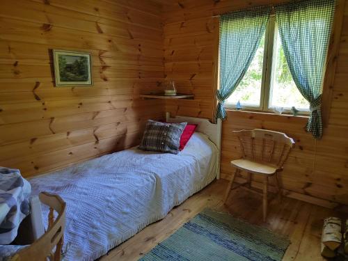 a bedroom with a bed in a log cabin at Ilmastoitu huvila ja rantasauna in Keuruu