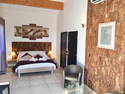 - une chambre avec un lit et une chaise dans l'établissement L'ESCALE COTE BLEUE VILLA & Spa Classée 4 Étoiles, à Sausset-les-Pins