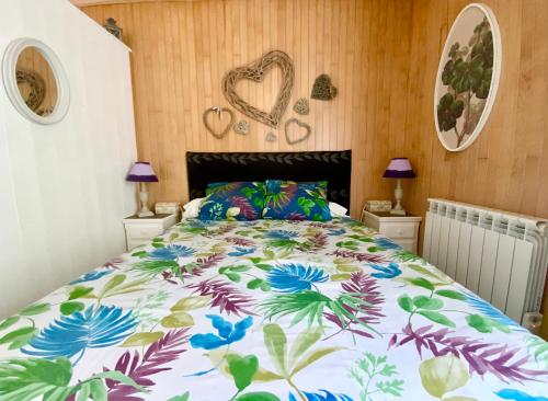 1 dormitorio con 1 cama grande con colcha de flores en Le Petit Prince à Sarlat - Parking privé - piscine chauffée - espace bien-être Jacuzzi et massages, en Sarlat-la-Canéda