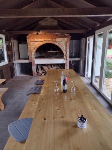 uma longa mesa de madeira num quarto com lareira em Lika Relax and Party House with sauna, jacuzzi and outdoor heated swimming pool em Lovinac