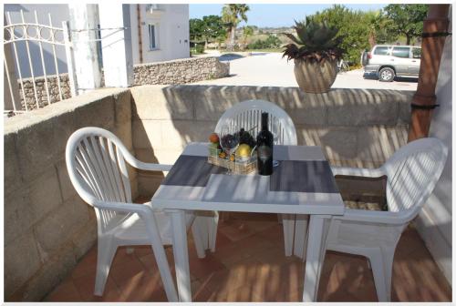 un tavolo con due sedie e un tavolo con bottiglie di vino di Appartamenti Mirabella a Favignana