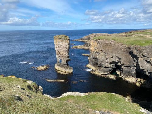 um pilar de rocha na água perto do oceano em Peedie Cott Self-Catering, Orkney em St Margaret's Hope