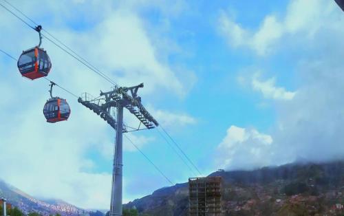 une remontée mécanique avec deux voitures dans le ciel dans l'établissement Habitación a pasos de teleféricos, à La Paz
