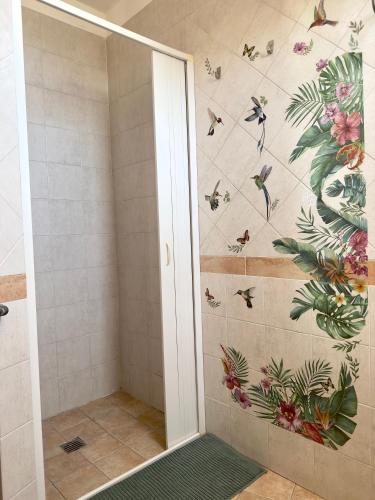 a bathroom with a shower with flowers and butterflies on the wall at Dimora Saracena Forio in Forio d'Ischia