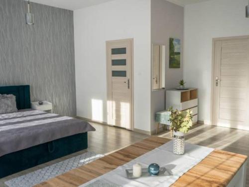 a bedroom with a bed and a table in it at Apartamenty Pod Fortami in Przemyśl