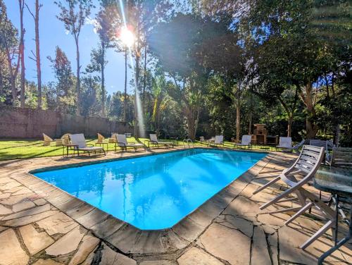 a swimming pool with chairs and a table at Mvuli Hotels Arusha in Arusha