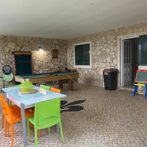 a table and chairs in a room with a stone wall at Venus House in Lamas