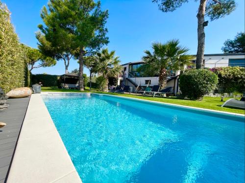 - une piscine dans une cour avec des arbres et une maison dans l'établissement L'ESCALE COTE BLEUE VILLA & Spa Classée 4 Étoiles, à Sausset-les-Pins