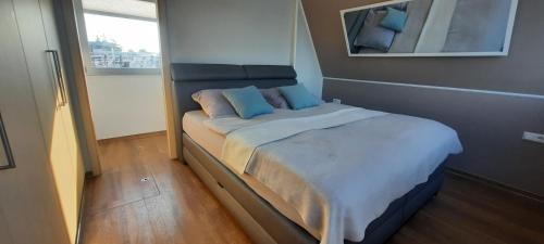 1 dormitorio con 1 cama grande con almohadas azules en Hausboot Amantes, en Brandenburg an der Havel