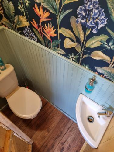un baño con lavabo e inodoro en Woodie the shepherds hut - sleeps 4, en Chichester