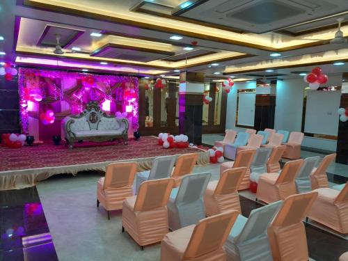 a room with a bunch of chairs and a stage at Rich Grand Hotel in Agra
