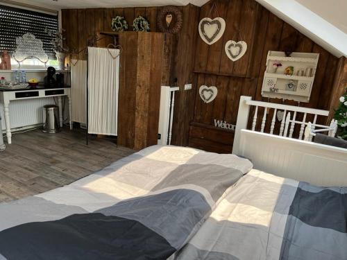 - une chambre avec un grand lit et des murs en bois dans l'établissement Grote zolderverdieping met gezellig zitje, à Woudenberg