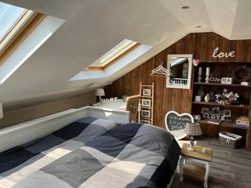 una camera da letto con un grande letto in mansarda di Grote zolderverdieping met gezellig zitje a Woudenberg