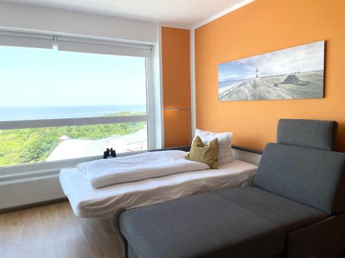 a bedroom with a bed and a chair and a window at Frische Brise FeWo12 09 in Cuxhaven