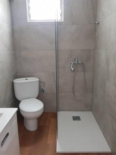 a bathroom with a toilet and a glass shower at Bella Vista in Piles