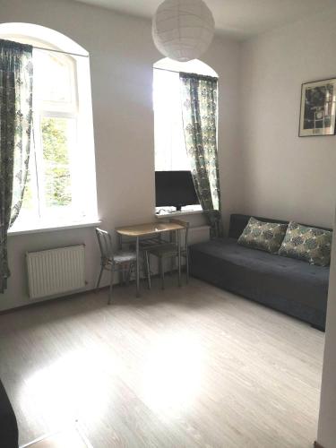 a living room with a couch and a table at Przytulne Mieszkanko Centrum in Mrągowo