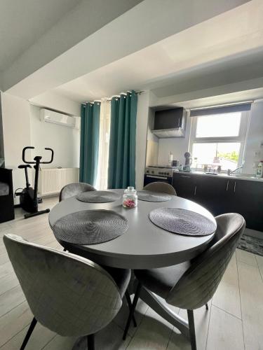 a dining room table with chairs and a kitchen at Welcome to Bucharest Airport Residences & Therme-SELF CHECK-IN in Otopeni