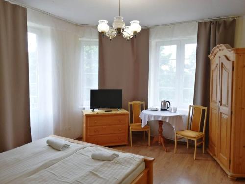 a bedroom with a bed and a table with a television at Rezydencja Zamek in Krynica Zdrój