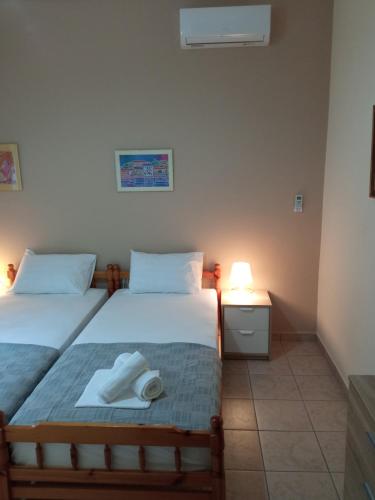 a bedroom with two beds and a lamp on a table at Sofia's Garden in Nea Peramos