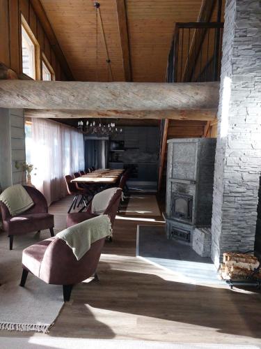 a living room with a fireplace and a table and chairs at Rovanperän kelomökit in Syöte