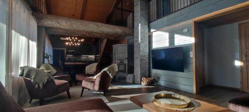 een woonkamer met een open haard en een televisie bij Rovanperän kelomökit in Syöte