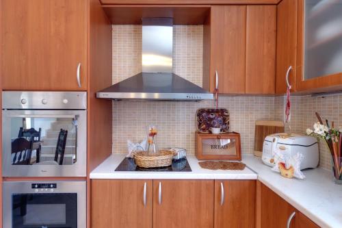 a kitchen with wooden cabinets and a stove top oven at Triopetra Luxury Villas Fournou Lago in Triopetra